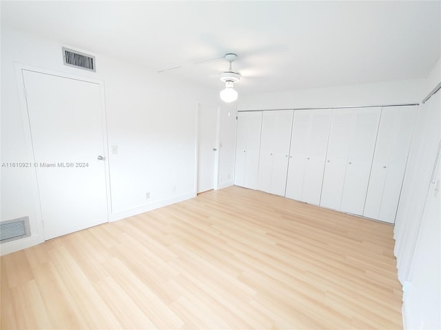 unfurnished bedroom with ceiling fan and light wood-type flooring