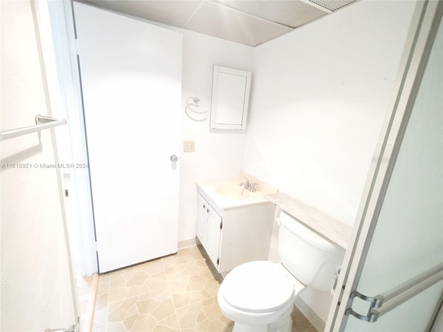 bathroom featuring vanity, tile patterned floors, and toilet