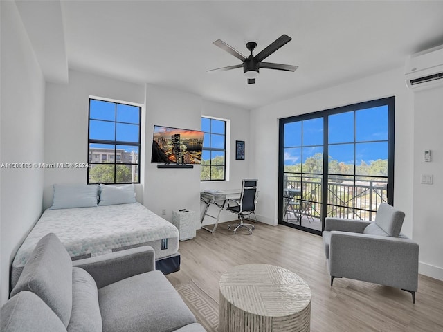 bedroom with a wall unit AC, a ceiling fan, wood finished floors, access to outside, and baseboards