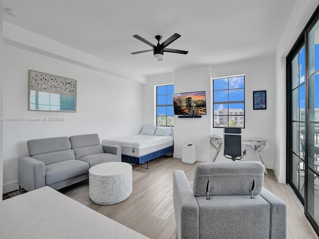 bedroom featuring ceiling fan, baseboards, and wood finished floors