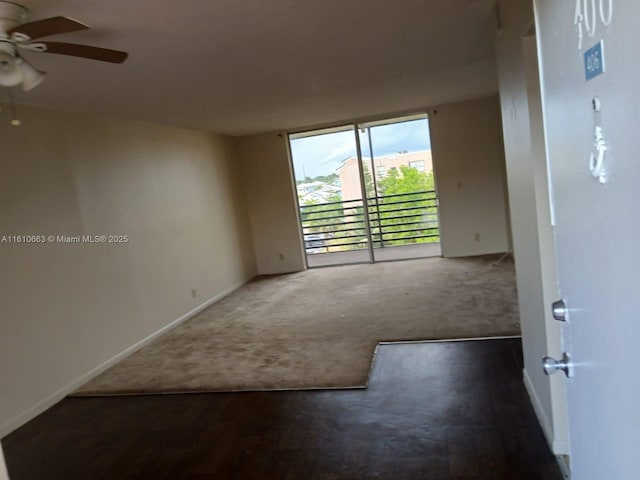 spare room with dark carpet and ceiling fan