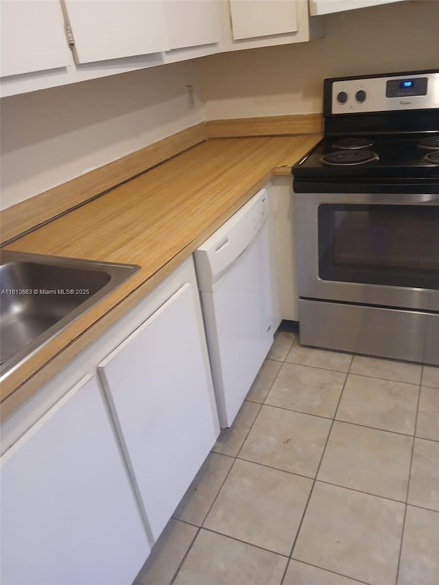 kitchen with light tile patterned floors, sink, dishwasher, white cabinetry, and electric range