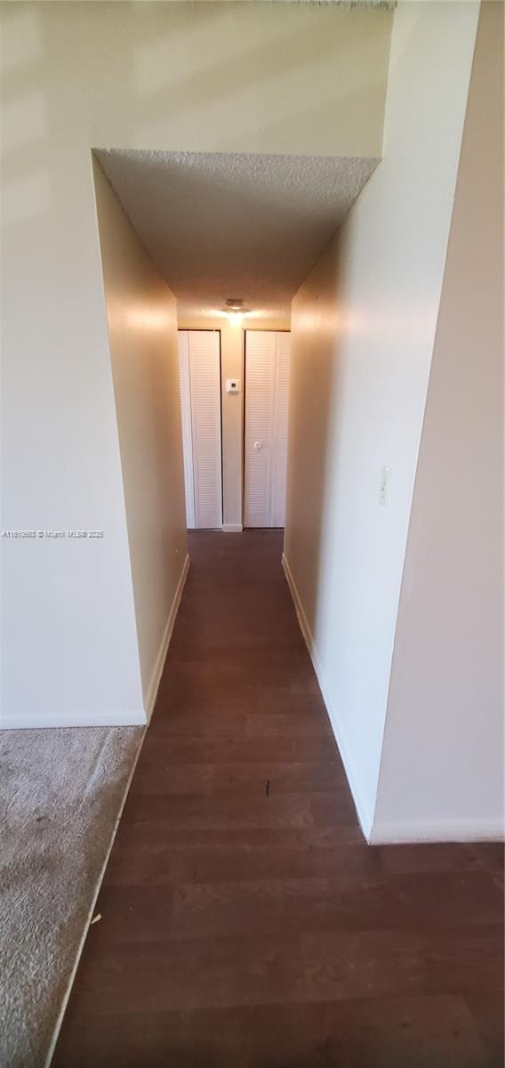 hallway with dark hardwood / wood-style flooring