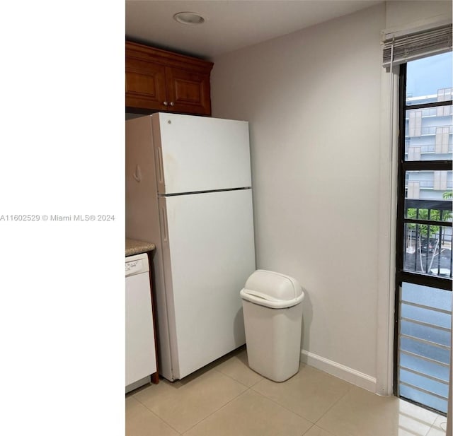 kitchen featuring white appliances and light tile patterned flooring