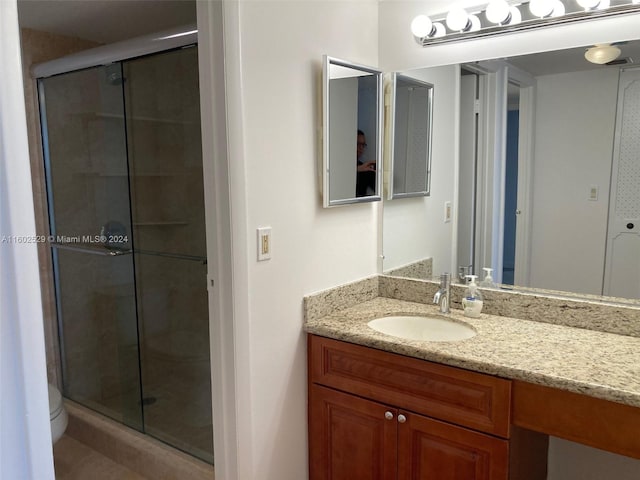 bathroom with vanity, toilet, and an enclosed shower