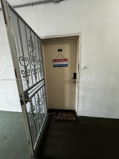 hallway featuring dark carpet