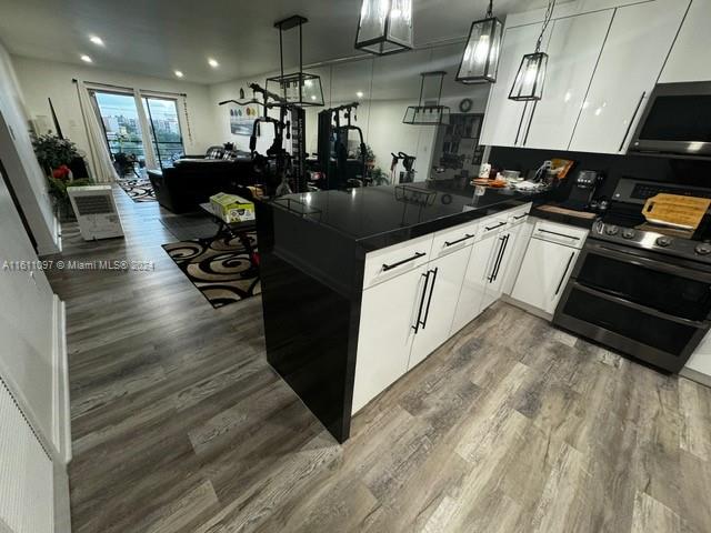 kitchen featuring white cabinets, dark hardwood / wood-style floors, and electric range