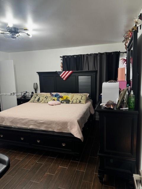 bedroom with dark wood-type flooring