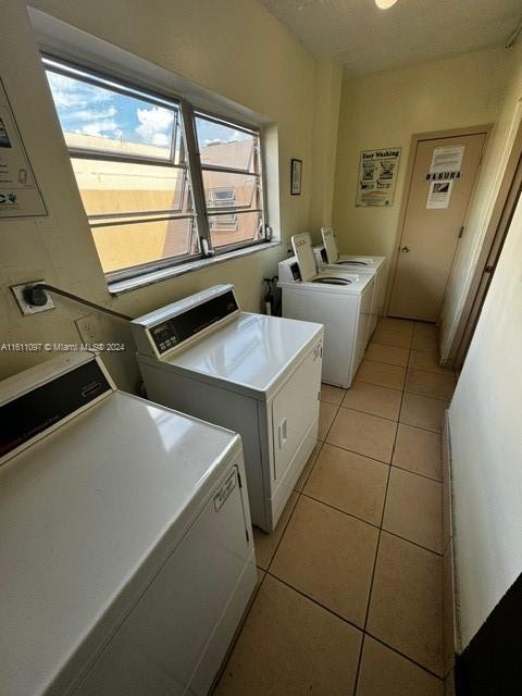 washroom featuring washer and dryer, plenty of natural light, and light tile floors