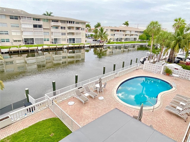 view of pool with a water view and a patio area