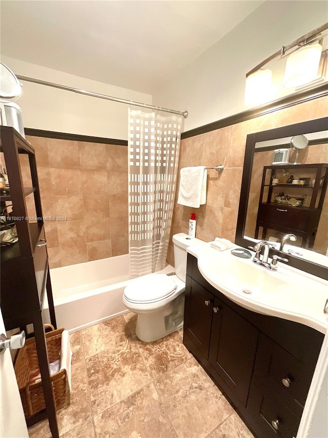 full bathroom featuring vanity, tile walls, shower / bath combo with shower curtain, and toilet