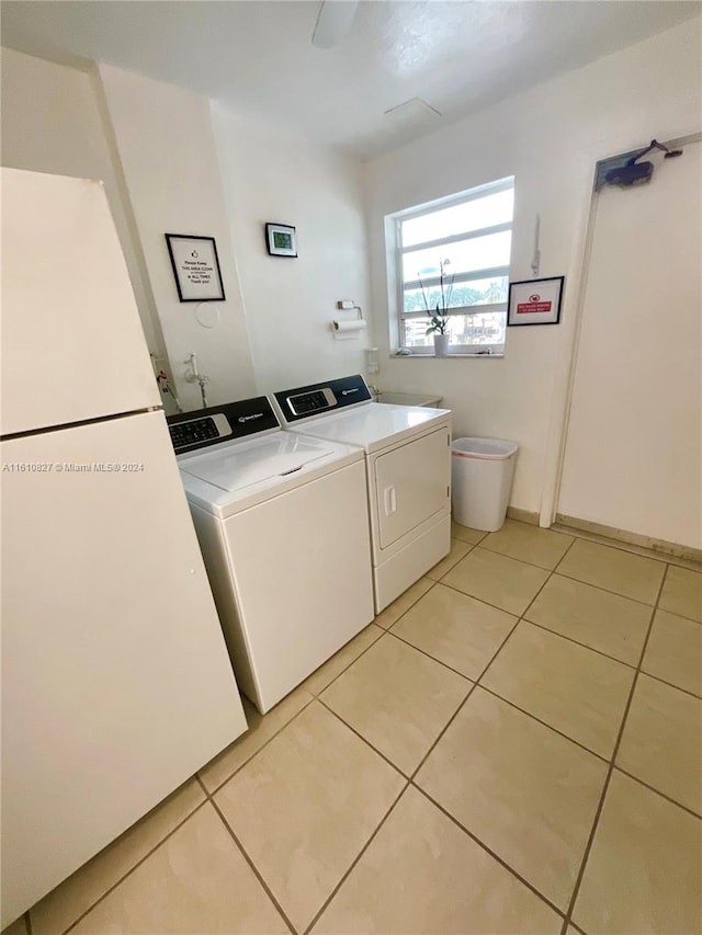 laundry area featuring washing machine and dryer and light tile patterned flooring