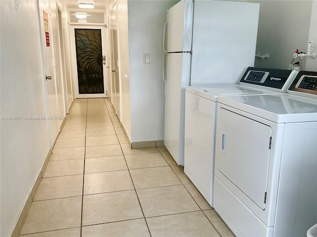 washroom with light tile patterned floors and washer and dryer