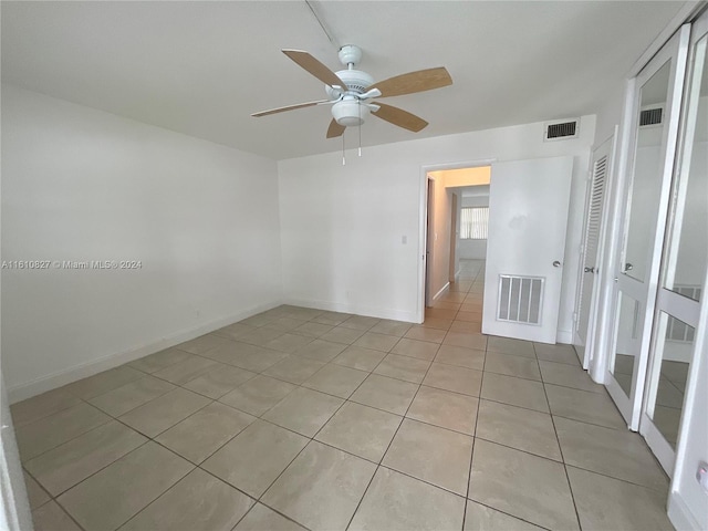 empty room featuring ceiling fan and light tile patterned floors