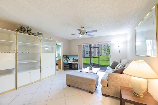 tiled living room with ceiling fan and a textured ceiling