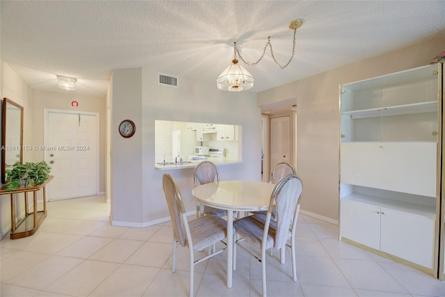 tiled dining room featuring a textured ceiling