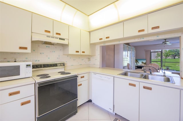 kitchen featuring white appliances, light tile patterned floors, decorative backsplash, sink, and white cabinets