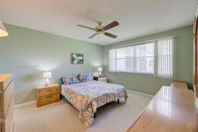 bedroom featuring light carpet, ceiling fan, a textured ceiling, and multiple windows