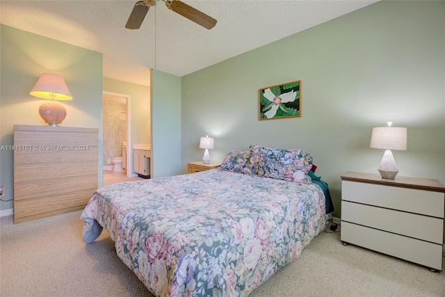 carpeted bedroom featuring a textured ceiling, ensuite bath, and ceiling fan