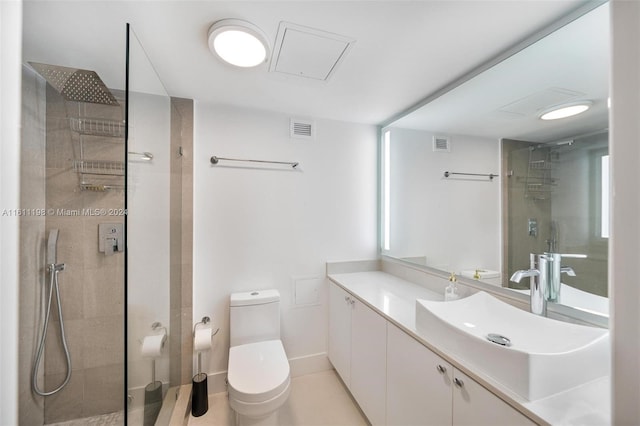 bathroom with tiled shower, vanity, and toilet