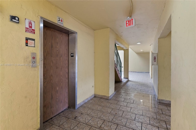 corridor featuring tile floors and elevator