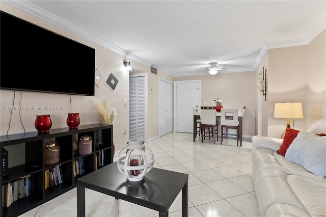 tiled living room with ornamental molding and ceiling fan