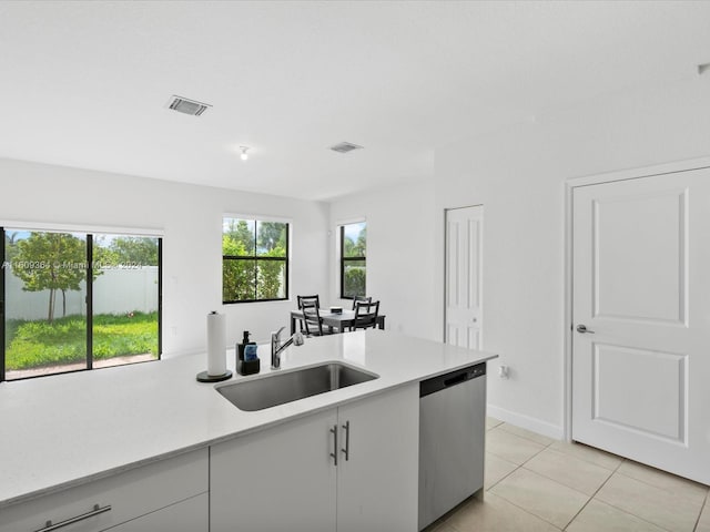 kitchen featuring sink, stainless steel dishwasher, and light tile floors