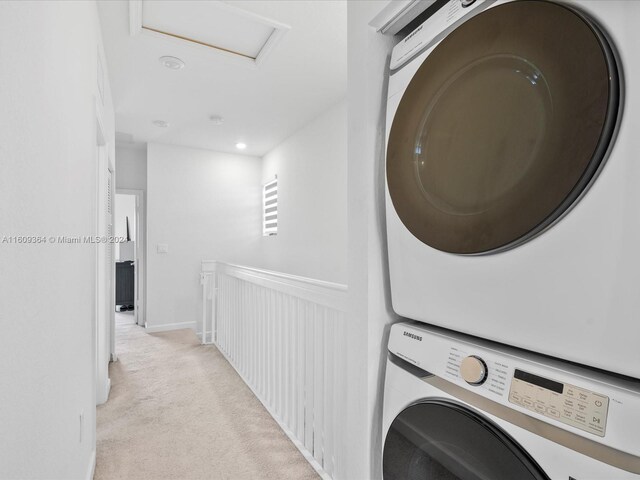 laundry room with stacked washing maching and dryer and light carpet