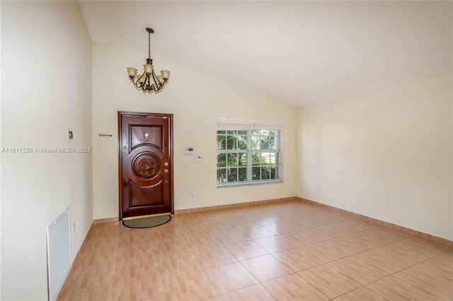 tiled foyer featuring lofted ceiling and an inviting chandelier