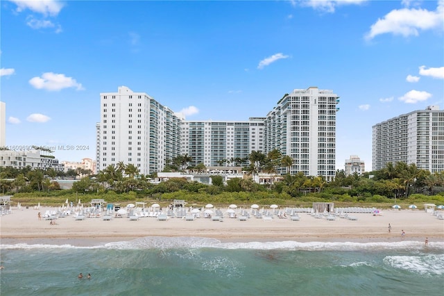 view of property with a water view and a beach view