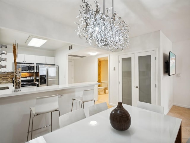 tiled dining area with an inviting chandelier