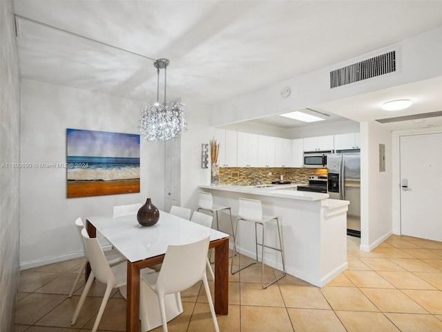 dining room with light tile patterned floors and a chandelier