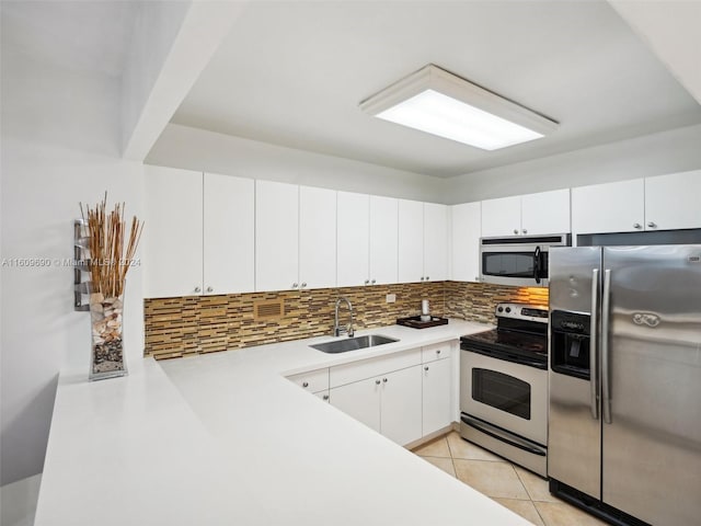 kitchen with sink, white cabinets, light tile patterned floors, and appliances with stainless steel finishes