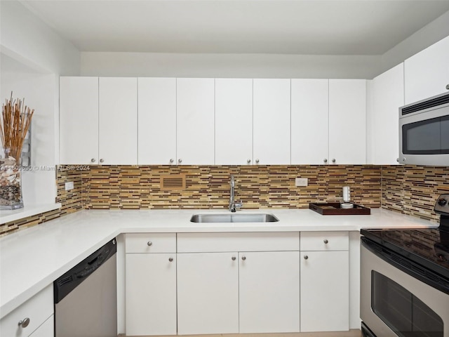 kitchen featuring stainless steel appliances, white cabinetry, tasteful backsplash, and sink