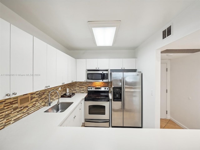 kitchen with white cabinetry, sink, backsplash, light tile patterned floors, and appliances with stainless steel finishes