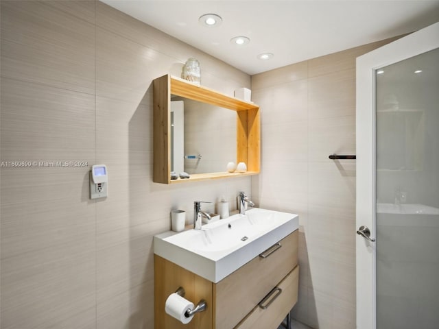 bathroom with vanity and tile walls