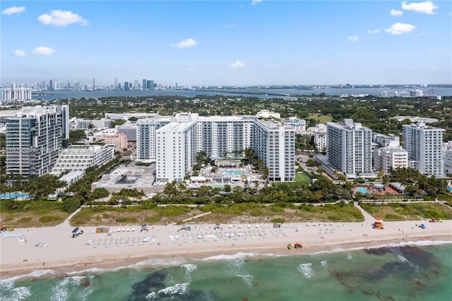 drone / aerial view featuring a beach view and a water view