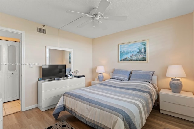 bedroom with a closet, ceiling fan, a textured ceiling, and light wood-type flooring