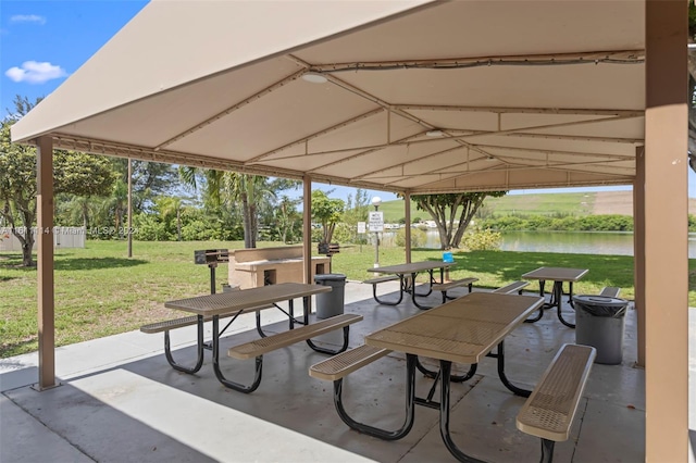 view of community featuring a water view, a patio, and a yard