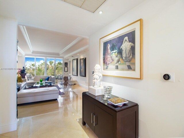 hallway featuring light tile patterned flooring and a raised ceiling