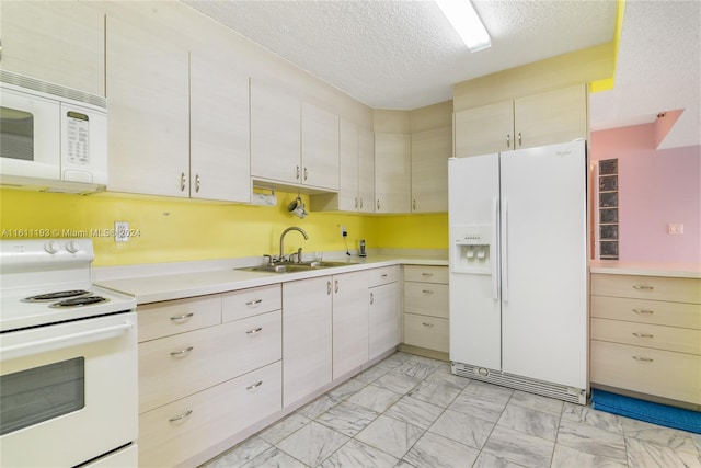 kitchen featuring sink, a textured ceiling, white appliances, and light tile floors