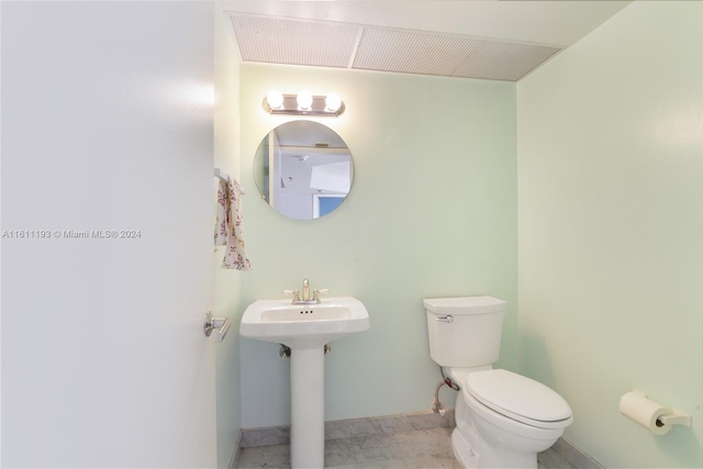 bathroom featuring tile flooring, sink, and toilet