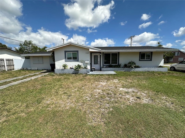 ranch-style home featuring a front lawn and fence