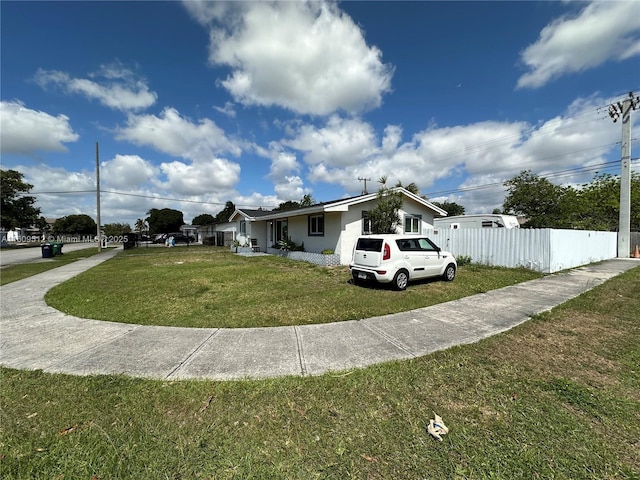 view of front of property with a front yard, fence, and stucco siding