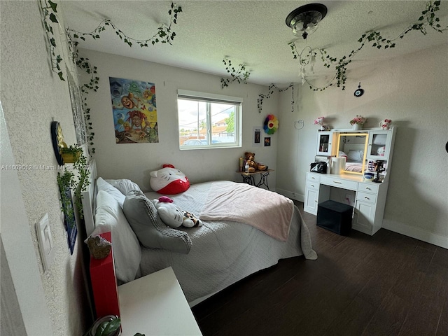 bedroom featuring dark wood-style flooring, baseboards, and a textured ceiling