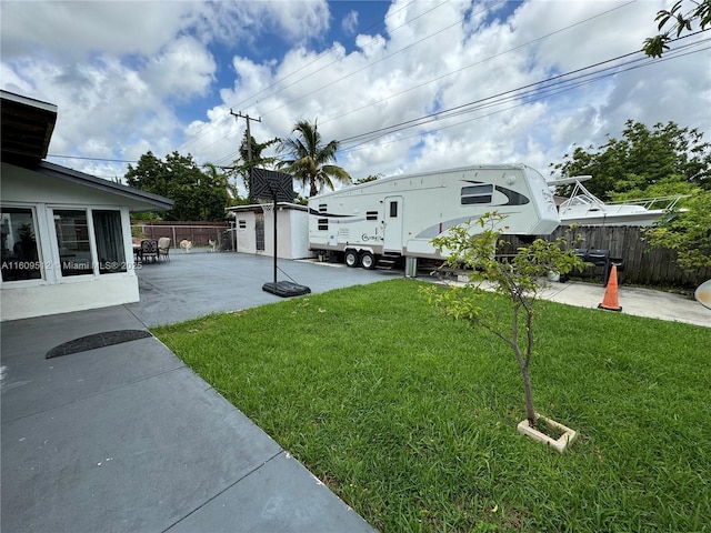 view of yard with a storage unit and a patio