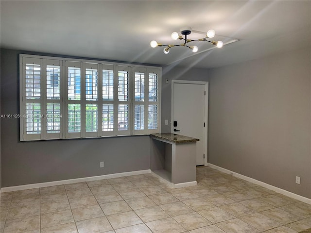 interior space with light tile patterned flooring, an inviting chandelier, and a wealth of natural light