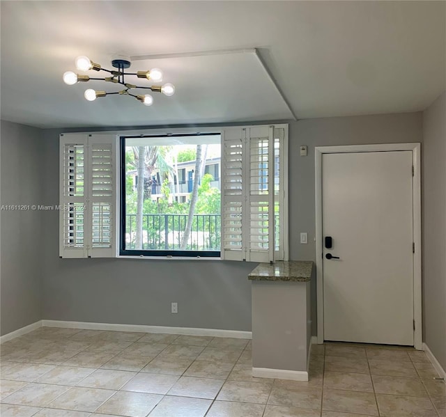 tiled entrance foyer featuring an inviting chandelier