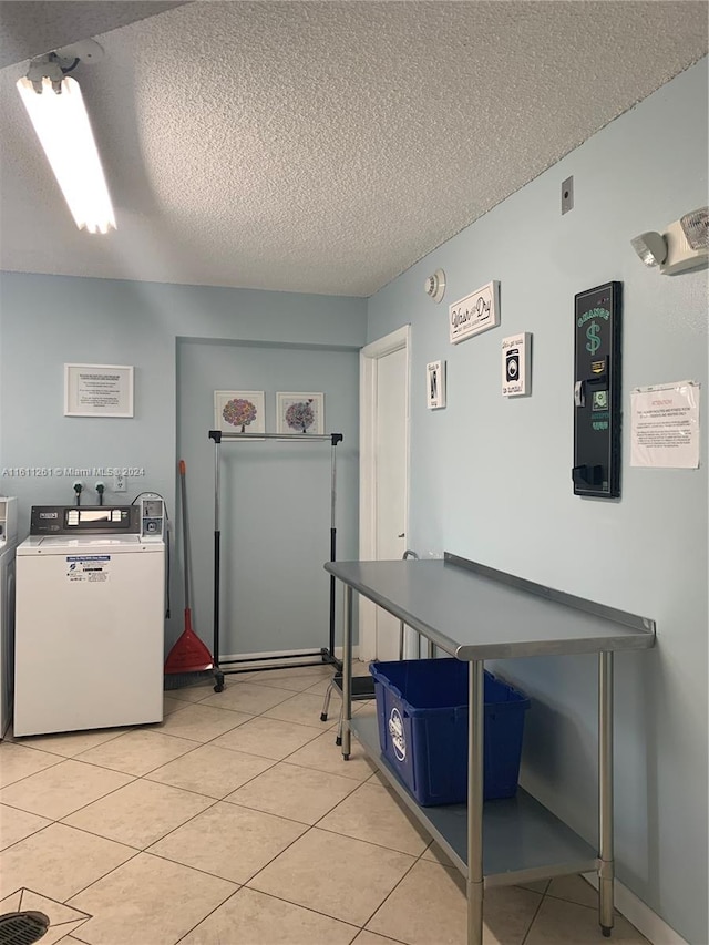 interior space with washing machine and clothes dryer, a textured ceiling, and light tile patterned flooring