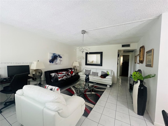 tiled living room with a chandelier and a textured ceiling